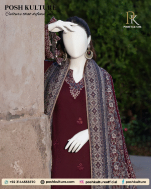 Mannequin wearing a deep red/maroon embroidered Dhanak shirt with plain trousers and a richly printed soft wool shawl, set against an outdoor background.