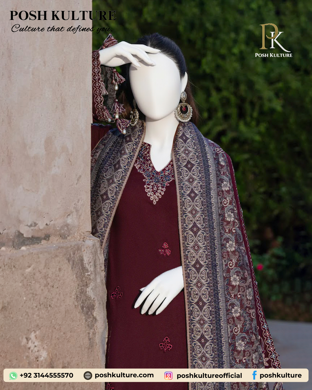 Mannequin wearing a deep red/maroon embroidered Dhanak shirt with plain trousers and a richly printed soft wool shawl, set against an outdoor background.