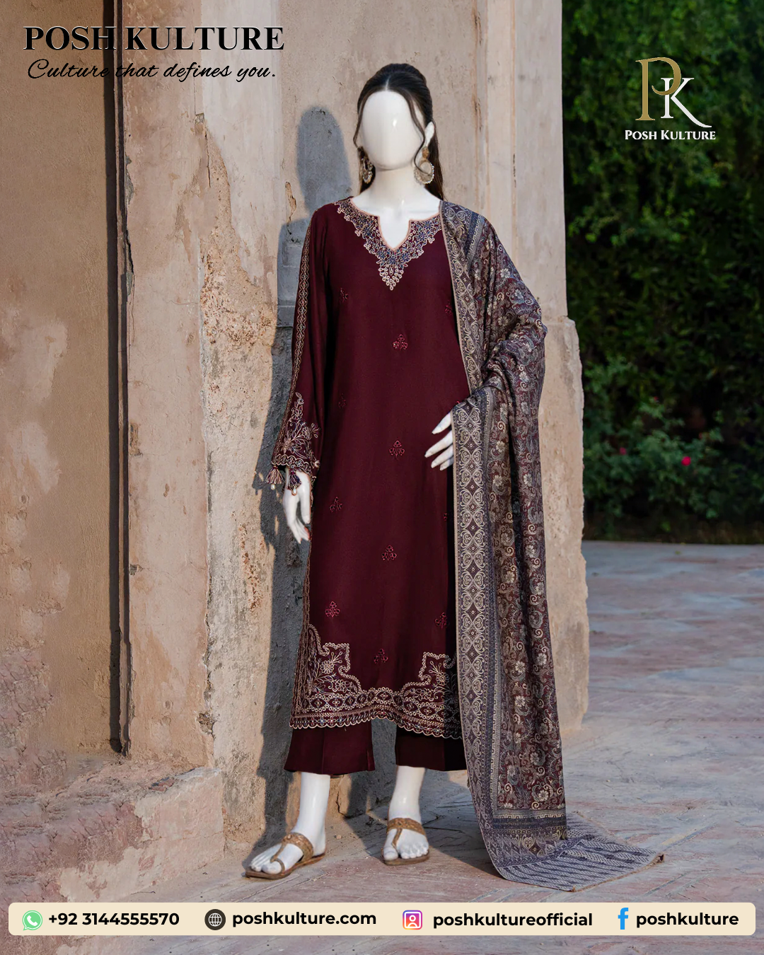 Mannequin wearing a deep red/maroon embroidered Dhanak shirt with plain trousers and a richly printed soft wool shawl, set against an outdoor background.